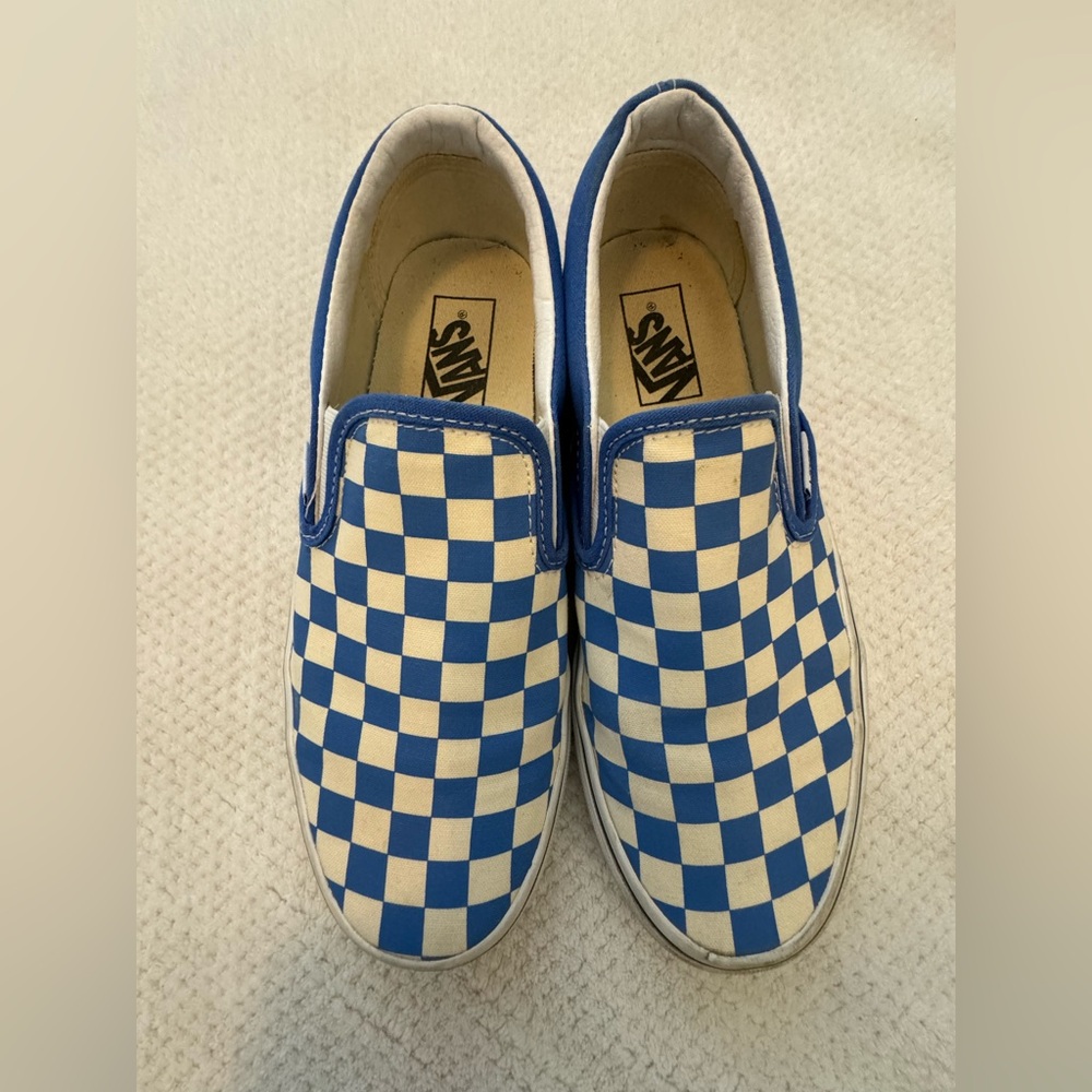 Blue checkerboard Vans slip ons.